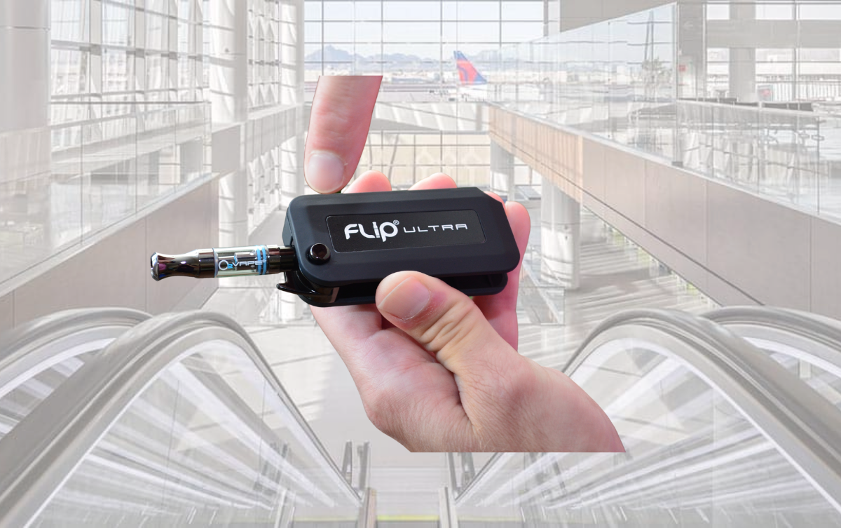 A vape being held in a hand with airport background 